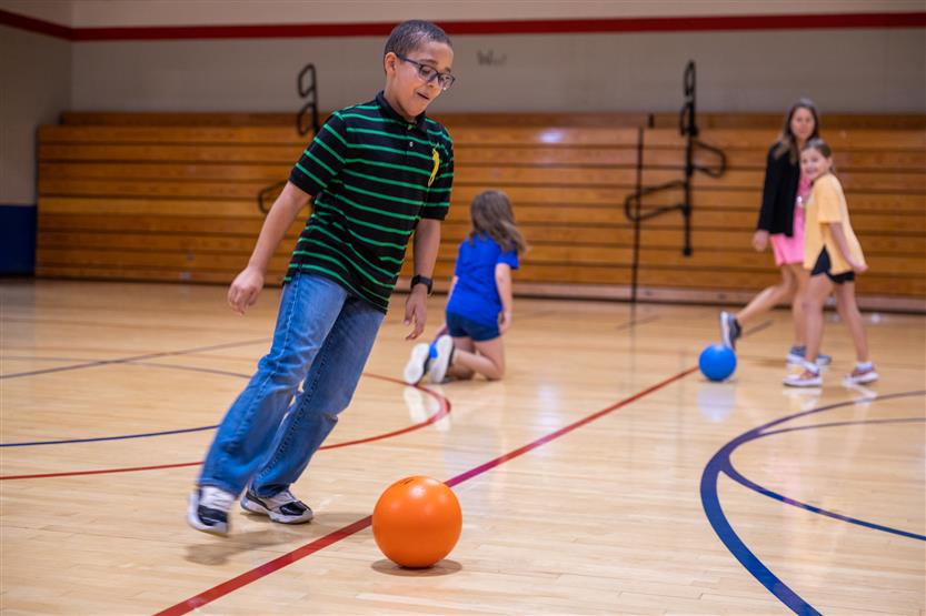 A boy dribbles the soccer ball